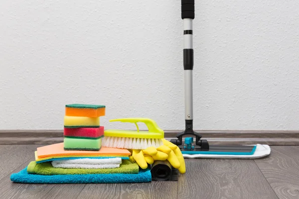 Equipamento de limpeza no chão contra a parede branca — Fotografia de Stock