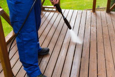 cleaning wooden terrace with high pressure washer clipart