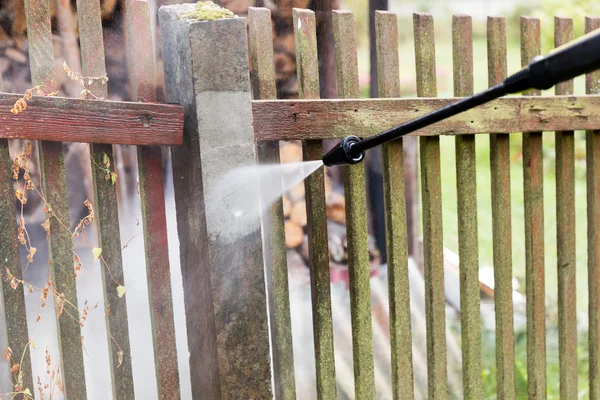 Καθαρισμού post βρώμικο φράκτη των κήπων με μηχάνημα πλύσης υψηλής πίεσης — Φωτογραφία Αρχείου