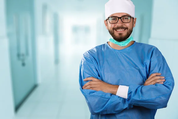 Feliz sorridente médico cirurgião de pé no corredor do hospital — Fotografia de Stock