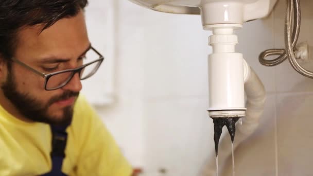 Loodgieter tot vaststelling van de sifon van de wasbak in een badkamer of keuken — Stockvideo