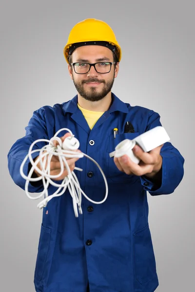Eletricista sorridente com ferramentas isoladas em fundo cinza — Fotografia de Stock