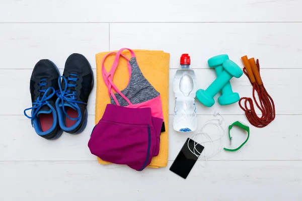 Vista superior de artículos de entrenamiento de fitness en el piso blanco del gimnasio — Foto de Stock