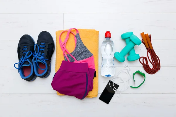 Top view of fitness workout items on white gym floor — ストック写真