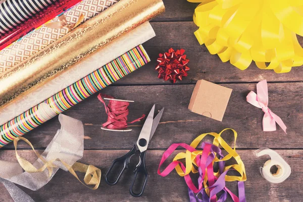 Gift wrapping rolls and accessories on the table — Stock Photo, Image