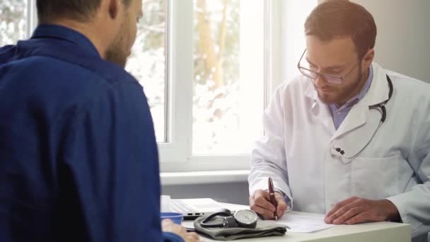 Visita al médico - escribir prescripción para el paciente — Vídeo de stock