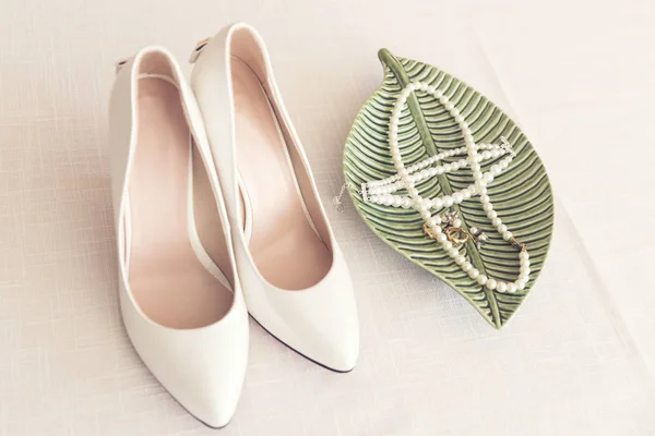 Zapatos de novia y joyería de perlas en la mesa —  Fotos de Stock