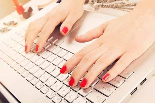 Mode vrouw met rode gepolijst nagels die op laptop werkt. schrijven — Stockfoto