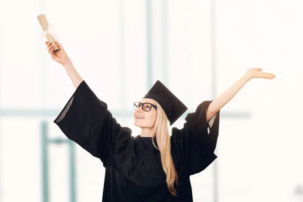 Glückliche Universitätsabsolventin mit Mütze und Kleid mit Diplom — Stockfoto