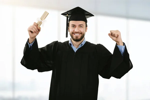 Alegre sorrindo graduado vestindo vestido na cerimônia de formatura — Fotografia de Stock