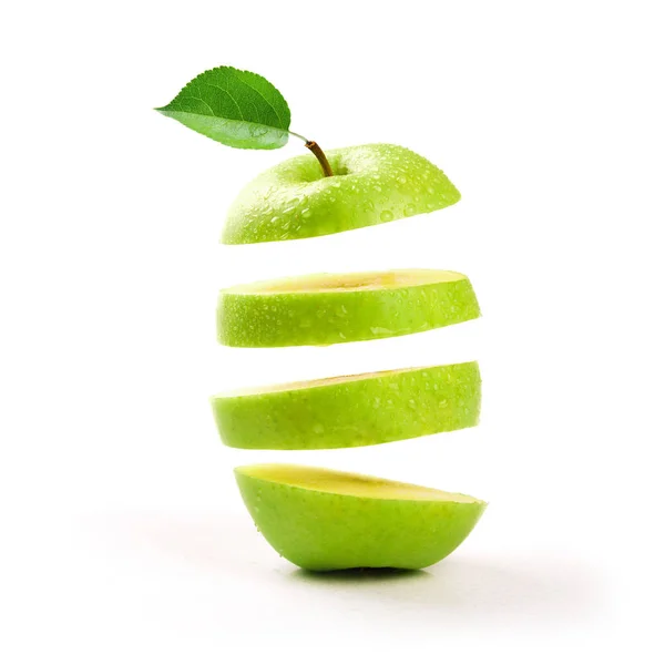 In Scheiben geschnittener grüner Apfel schwebt auf weißem Hintergrund — Stockfoto