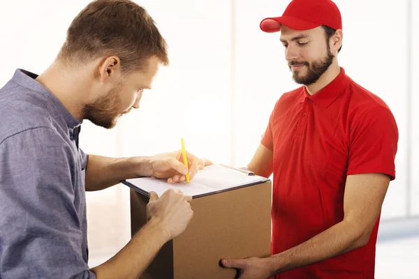 Doručovací služba - muž podpisu potvrzení o doručení boxu — Stock fotografie