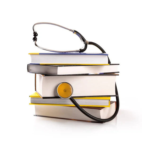 Медицинское образование - стопка книг со стетоскопом на белом — стоковое фото