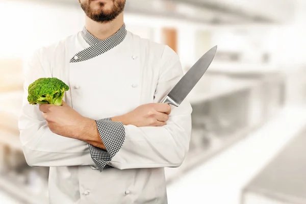 Σεφ στην κουζίνα του εστιατορίου με το μπρόκολο και το μαχαίρι στα χέρια — Φωτογραφία Αρχείου