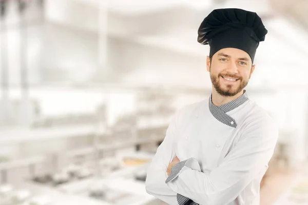 Ευτυχισμένο σεφ χαμογελαστός στέκεται στην κουζίνα. χώρο αντίγραφο — Φωτογραφία Αρχείου