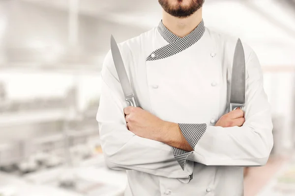 Chef de pé na cozinha do restaurante com facas nas mãos — Fotografia de Stock