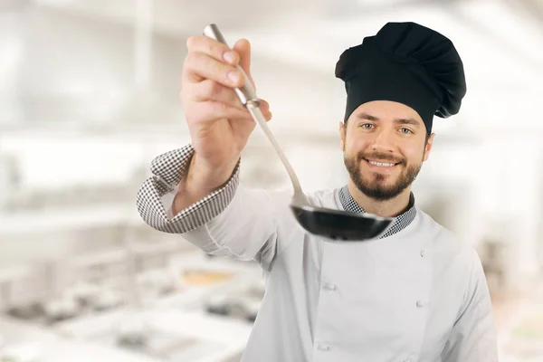 Gelukkig chef-kok in de keuken van het restaurant met pollepel in de hand — Stockfoto