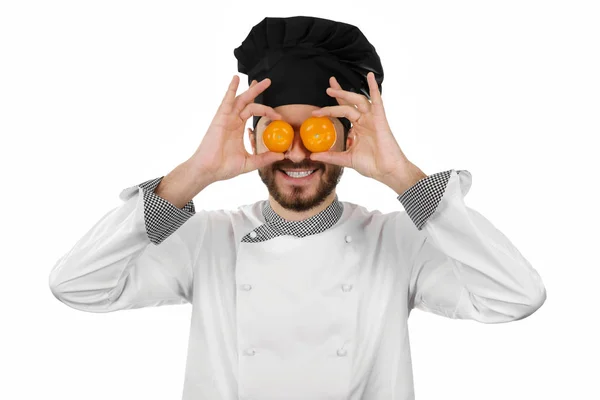 Chef feliz cobrindo seus olhos com tomates isolados em branco — Fotografia de Stock