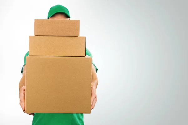 Doručovatel drží hromadu lepenky boxy vpředu s kopií prostor — Stock fotografie