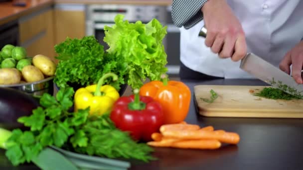 Chef cortar eneldo sobre tabla de madera en la cocina — Vídeo de stock