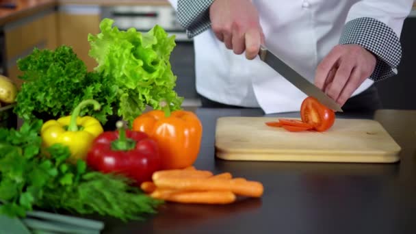 Шеф-повар режет помидоры на борту на кухне — стоковое видео
