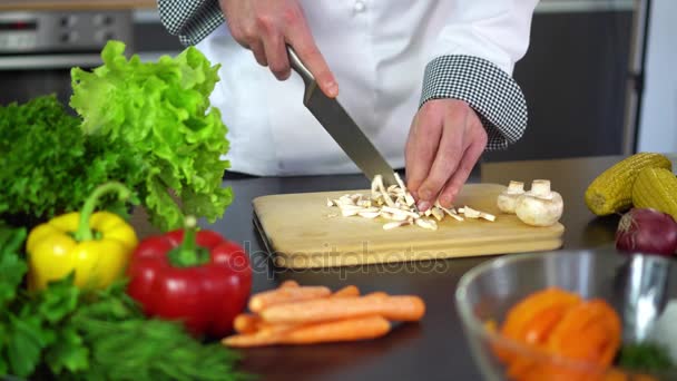 Chef picando champiñón sobre tabla de madera para cocinar en la cocina — Vídeo de stock