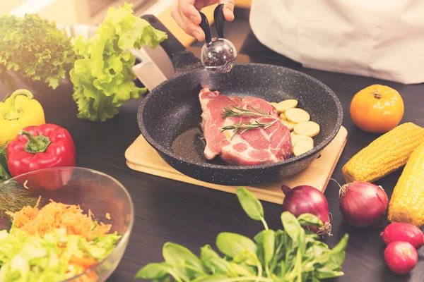 Chef preparing steak with potato in a pan — Stock Photo, Image