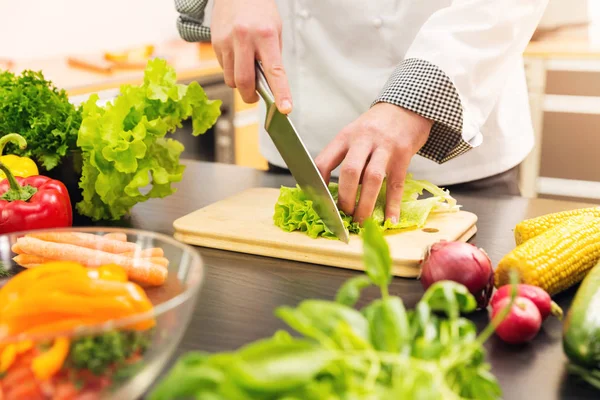 Saine alimentation - chef coupe la laitue dans la cuisine — Photo