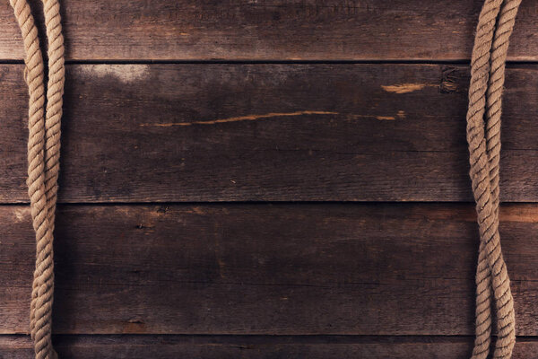 Выветренные веревки корабля на старом деревянном фоне
