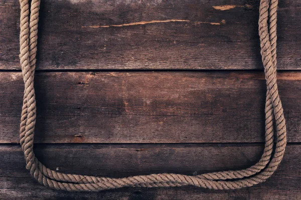 Old rope on wood plank background — Stock Photo, Image
