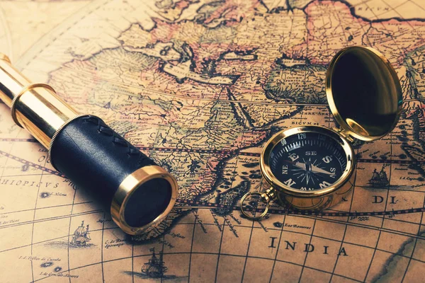 Vintage compass and spyglass on old world map — Stock Photo, Image