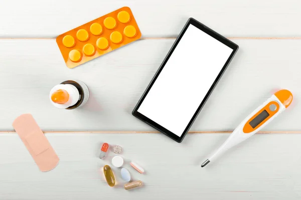Smartphone em branco com itens médicos na mesa. vista superior — Fotografia de Stock