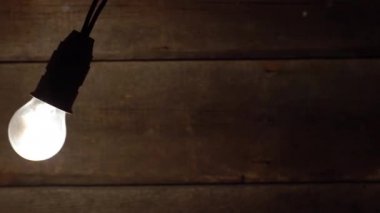 Vintage eski ahşap arka plan üzerinde sallanan ampul