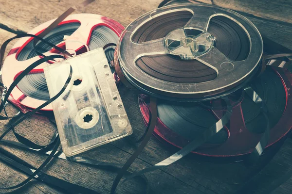 Retro audio reels and cassette on old wooden table — Stock Photo, Image