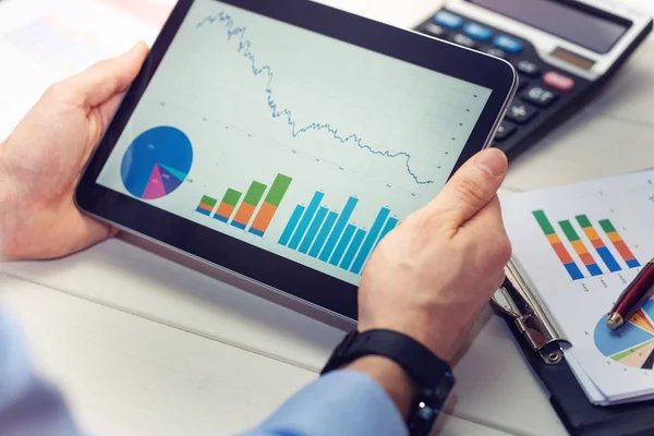 Üzletember gazdaság digitális tábla a grafikonok és diagramok — Stock Fotó