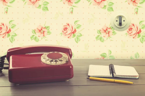 Старий телефон з блокнотом на столі в старовинній кімнаті — стокове фото
