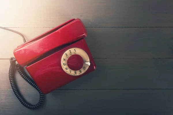 Starý červený telefon na dřevěný stůl s kopií prostor Royalty Free Stock Obrázky