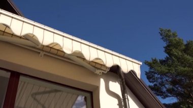 Mavi gökyüzü karşı balkon penceresi üzerinde açılış tente