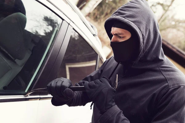 Крадіжка автомобіля - злодій намагається проникнути в автомобіль — стокове фото