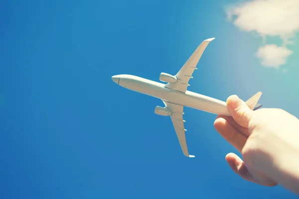Dreams of journey - hand with small airplane model against blue sky — Stock Photo, Image