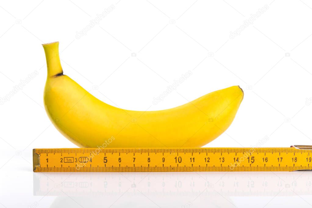 size matters concept, banana with ruler isolated on white