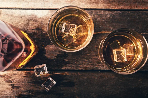 Whisky z lodem na stary ciemny drewniany stół. Widok z góry — Zdjęcie stockowe