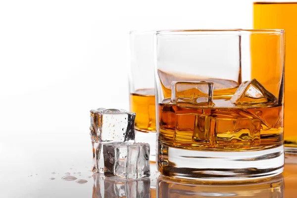 Sklenka na whisky s ledem na bílém pozadí — Stock fotografie