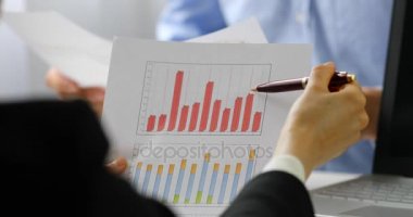 grafik ve Grafik raporları ofisinde tartışırken iş adamları