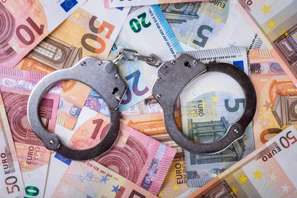 Denaro sporco e concetto di corruzione - manette con banconote in euro — Foto Stock