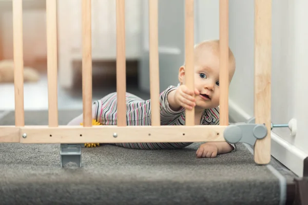 Enfant jouant derrière les barrières de sécurité devant les escaliers à la maison — Photo