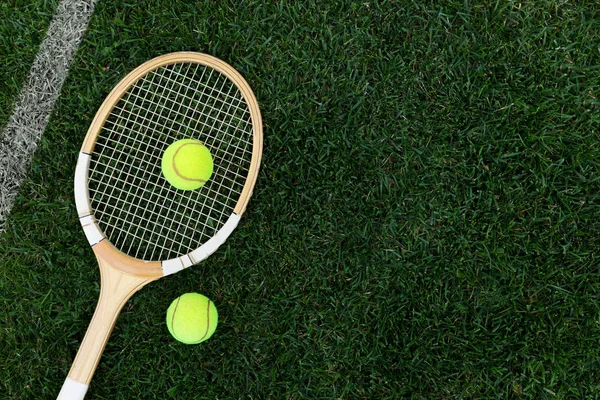 Raquete de tênis retro na grama natural com bolas. vista superior com espaço de cópia — Fotografia de Stock