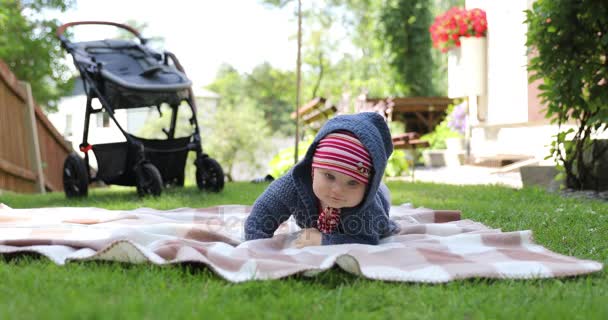 Ребенок учится ползать на домашнем заднем дворе — стоковое видео