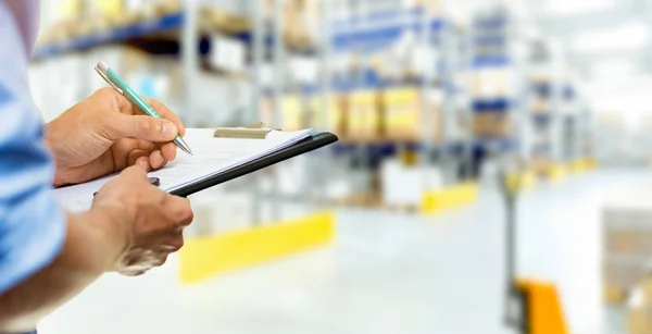 Serviço logístico homem escrevendo documentos na área de transferência em warehous — Fotografia de Stock