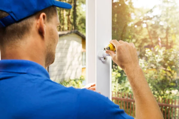 Trabajador instalando manija de ventana de plástico —  Fotos de Stock